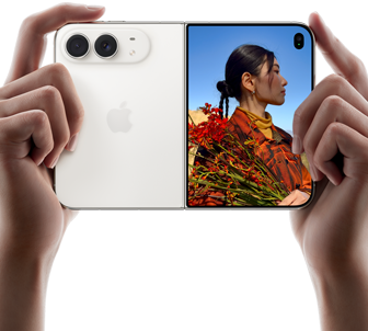 To hender holder iPhone Duo i fargen stjernehvit i liggende format. Det utbrettede venstre panelet viser 48 MP Dual Fusion-kameraene på baksiden. Høyre panel viser en person som blir tatt bilde av på frontskjermen. Personen kan se ansiktet sitt mens bildet tas med Duo Preview.