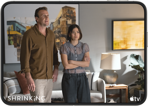 iPhone Duo, åpnet i liggende format, en scene fra Apple TV-serien «Shrinking» vises på skjermen